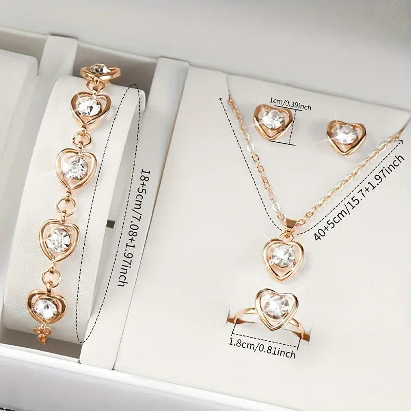 gold heart-shaped jewelry set with bracelet, necklace, ring, and earrings featuring clear stones