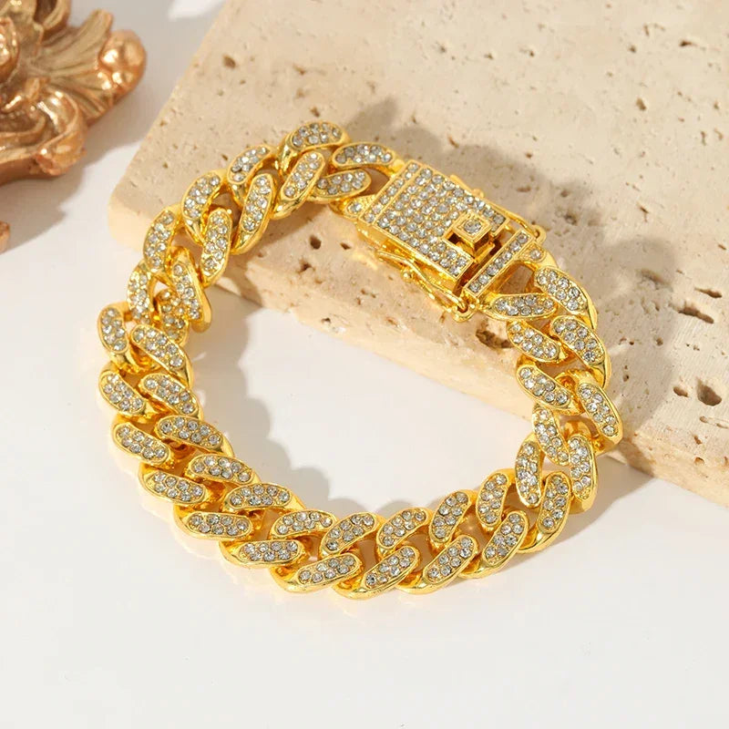 Gold Cuban link bracelet encrusted with clear crystals on beige stone background