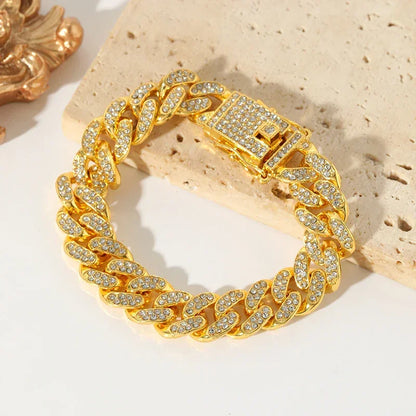 Gold Cuban link bracelet encrusted with clear crystals on beige stone background