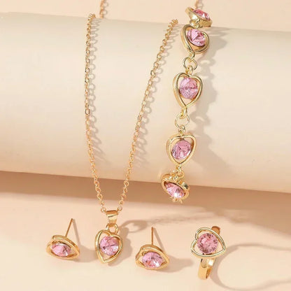 Gold jewelry set with pink heart-shaped gemstones necklace, bracelet, earrings, and ring