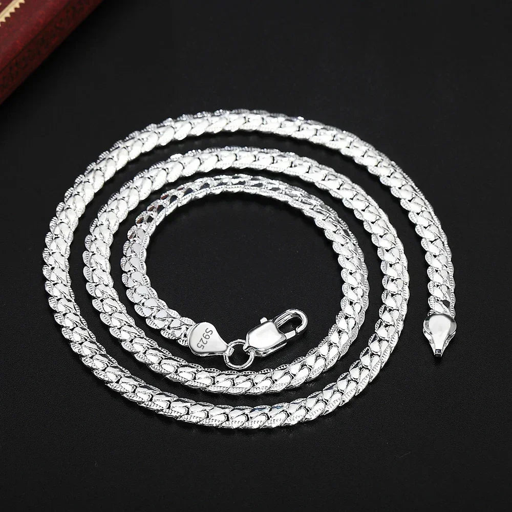Sterling silver 925 Cuban link chain necklace coiled on black background