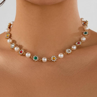 Close-up of elegant necklace with pearls and multicolored gemstone flower pendants on neck